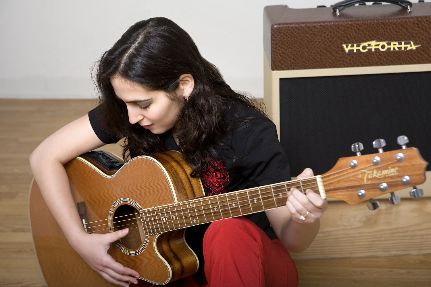 Photo of Rachel Rossos playing acoustic guitar